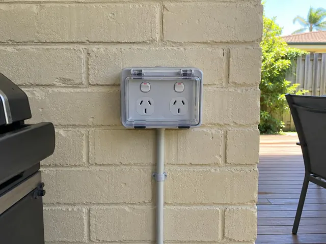 Weatherproof double power point on a cream brick exterior wall beside a patio in Nerang